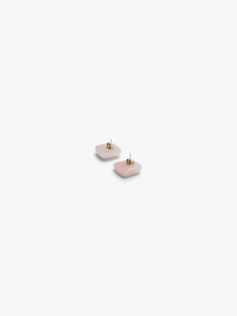 A pair of rose quartz stud earrings against a white background