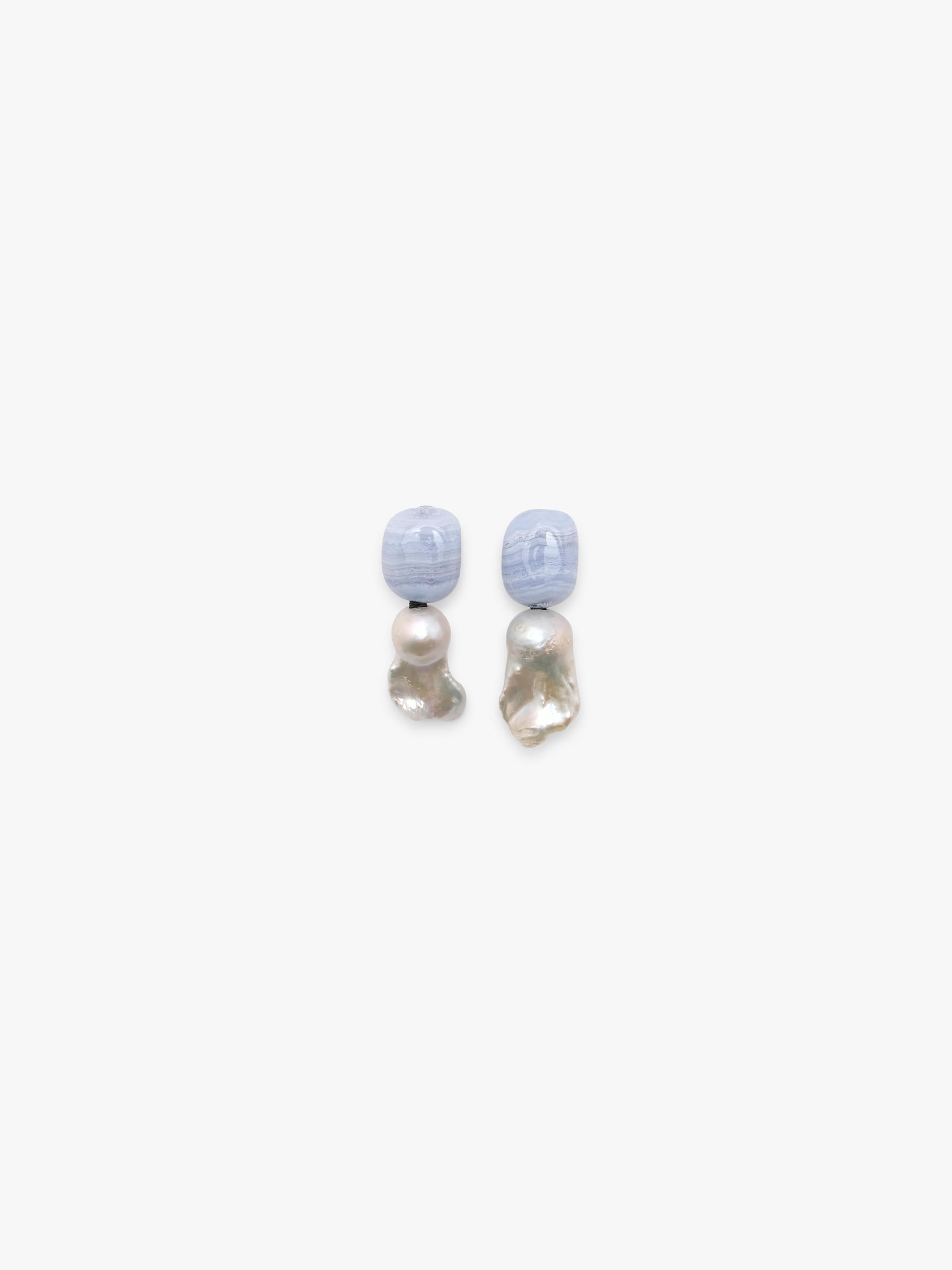 Dangle earrings in blue agate and baroque pearls. Displayed on a white backgorund