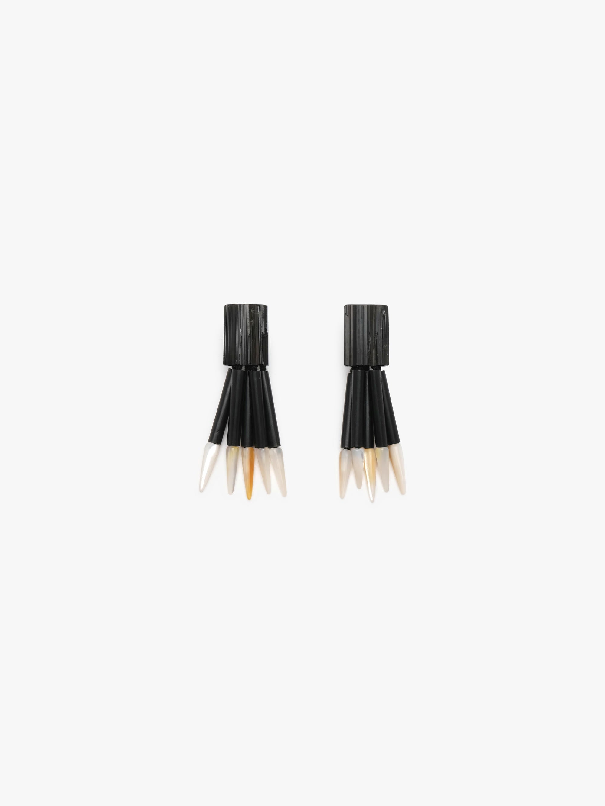 Black dangle earrings with white spears on a white background