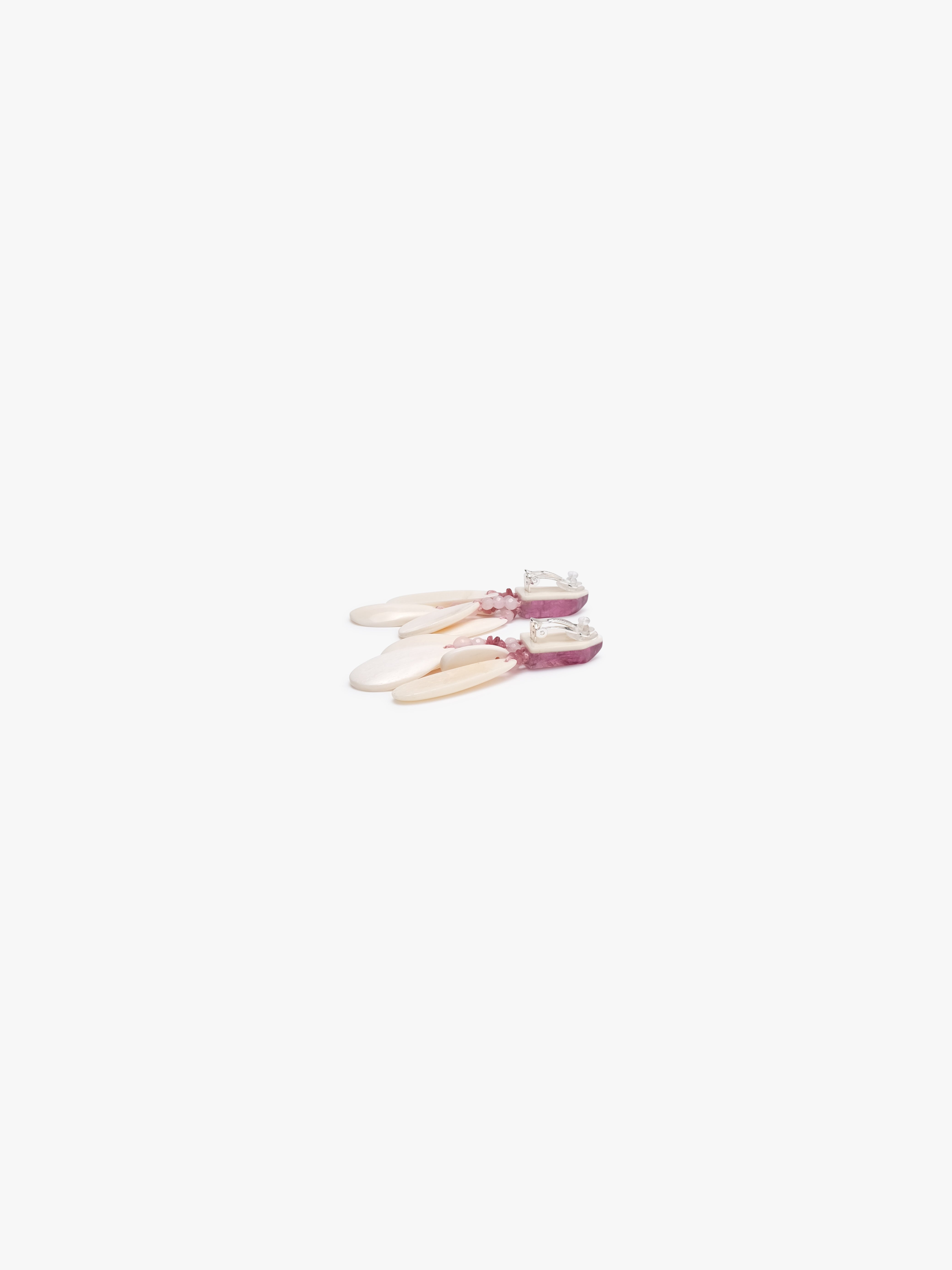 Earrings with pink stones and bone on a white background
