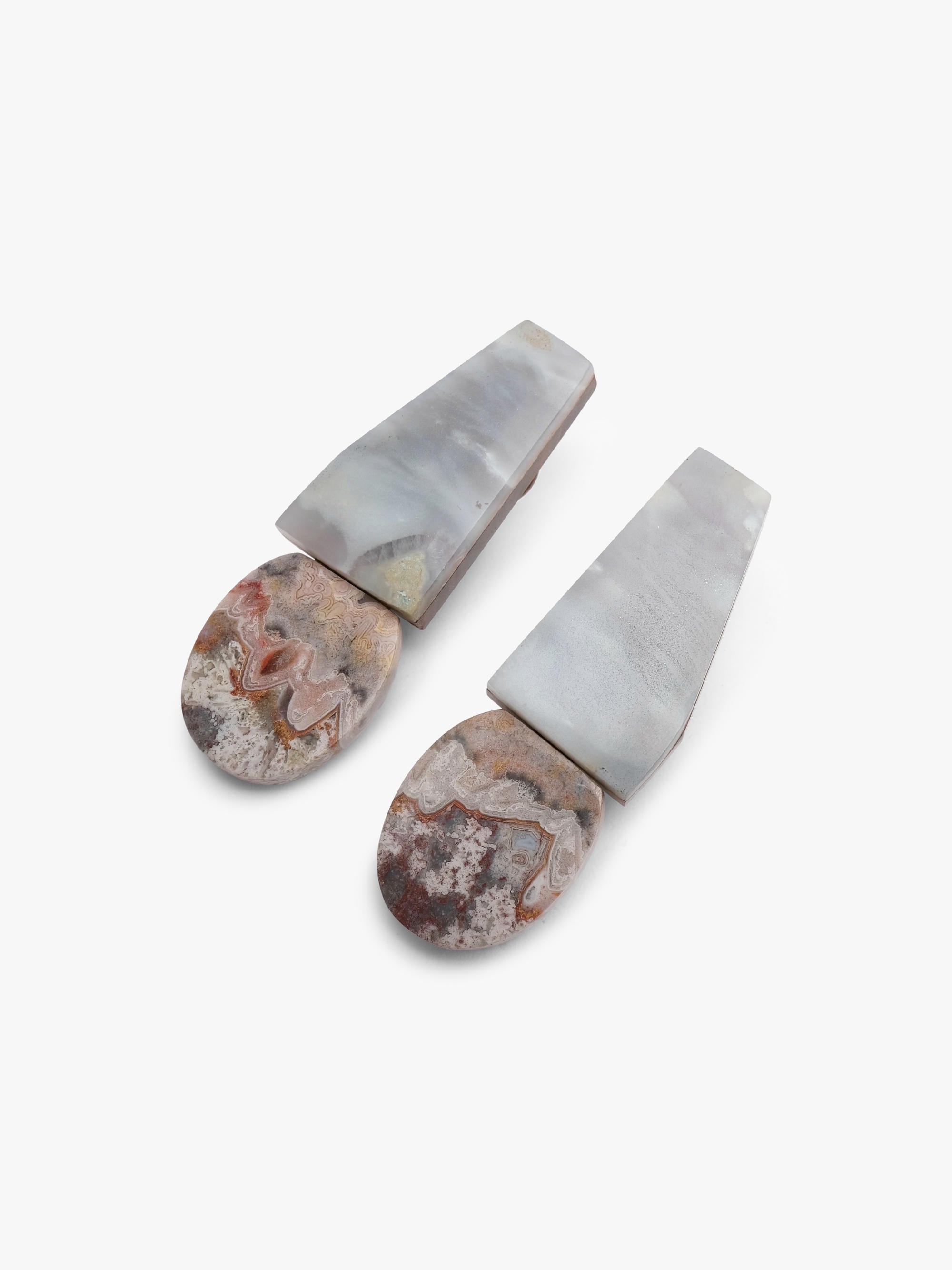 Two stone earrings with a geometric design on a white background