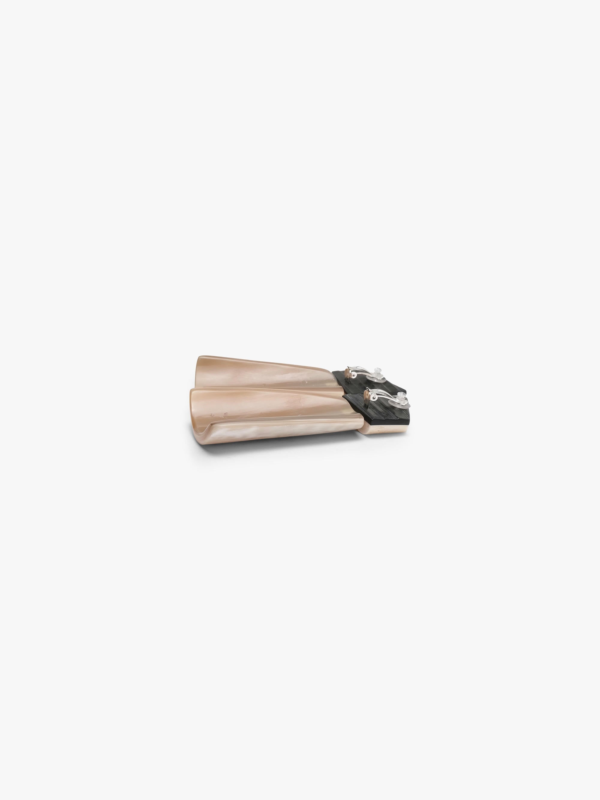 Pair of white earrings made of warthog tooth, cow horn and ebony on white background. 