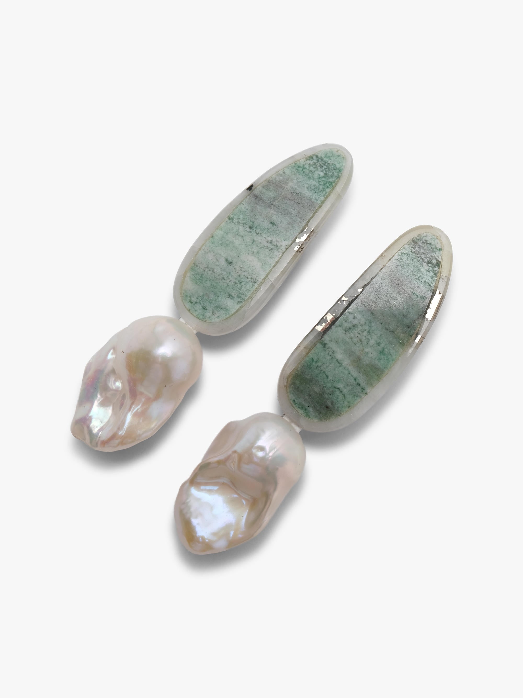 A pair of small drop earrings with green stone tops and baroque pearls, shown on a plain light gray background.