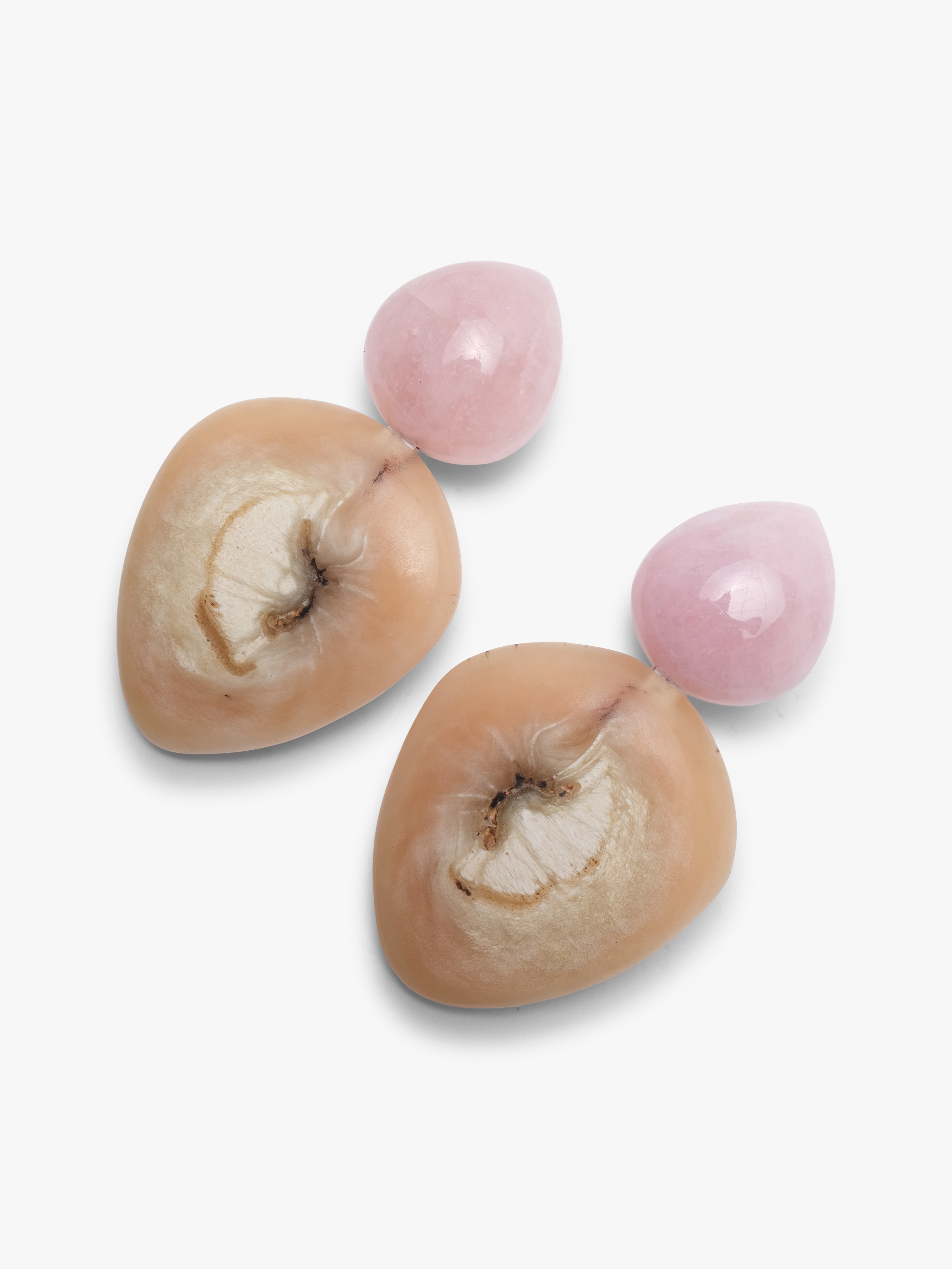 Pink and beige earrings mad eof horn and rose quartz on a white background