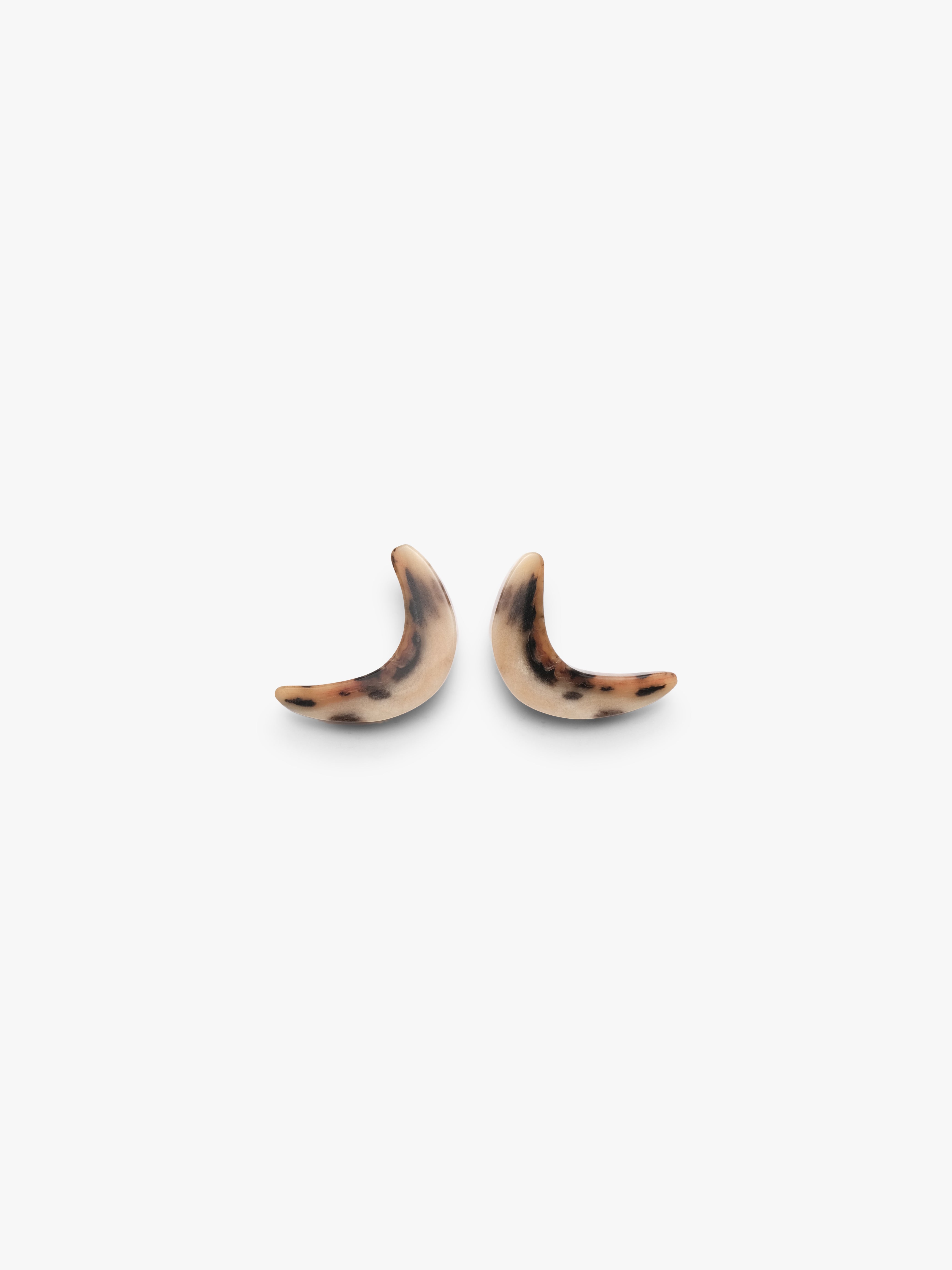 Two curved earrings in horn with animal print on a white background