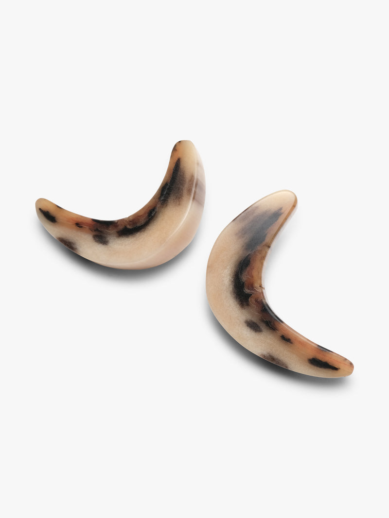 Pair of curved, tortoiseshell-patterned earrings on a white background