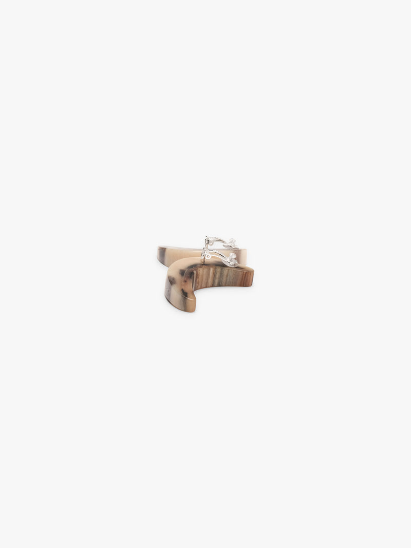 Two curved earrings in horn with animal print on a white background