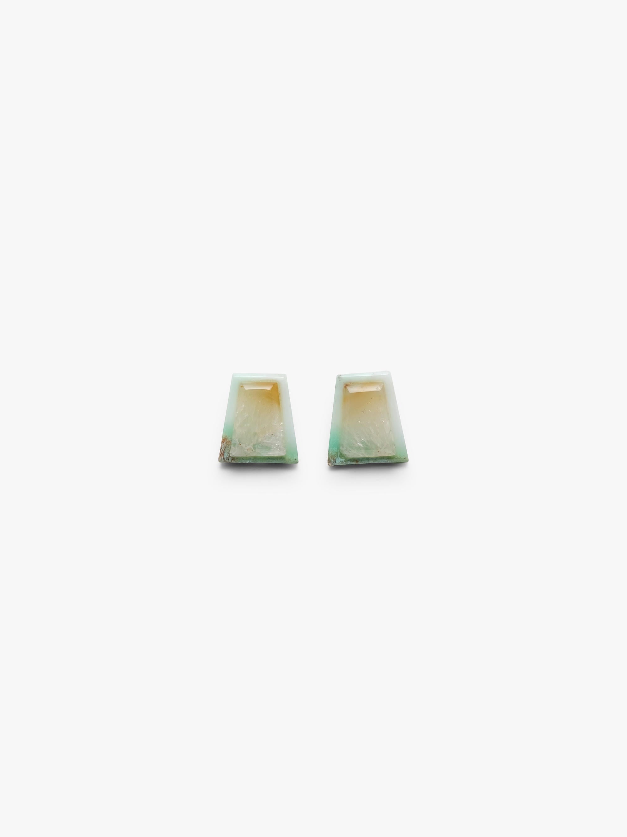 Pair of square-shaped earrings with blue stones on a white background