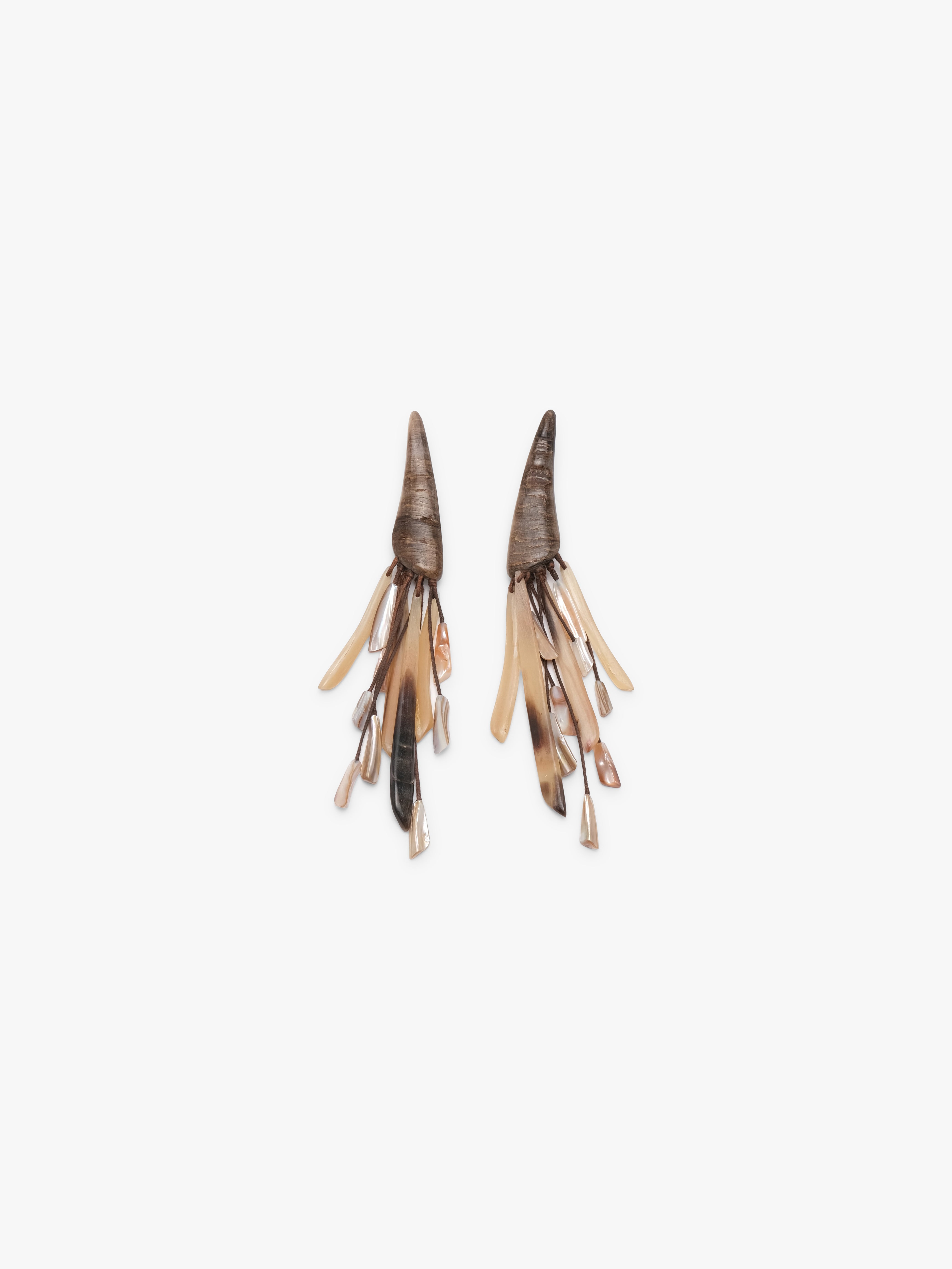 Pair of tassle earrings made from hornb and pearl on a white background
