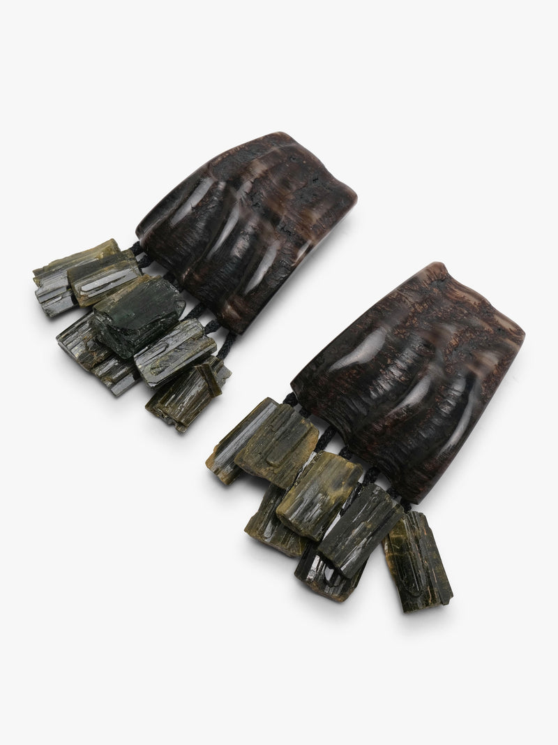 A pair of large drop earrings featuring dark brown carved wooden or bone-like upper sections with clustered natural stone or mineral fragments in gray, olive, and brown tones, shown on a plain light background.
