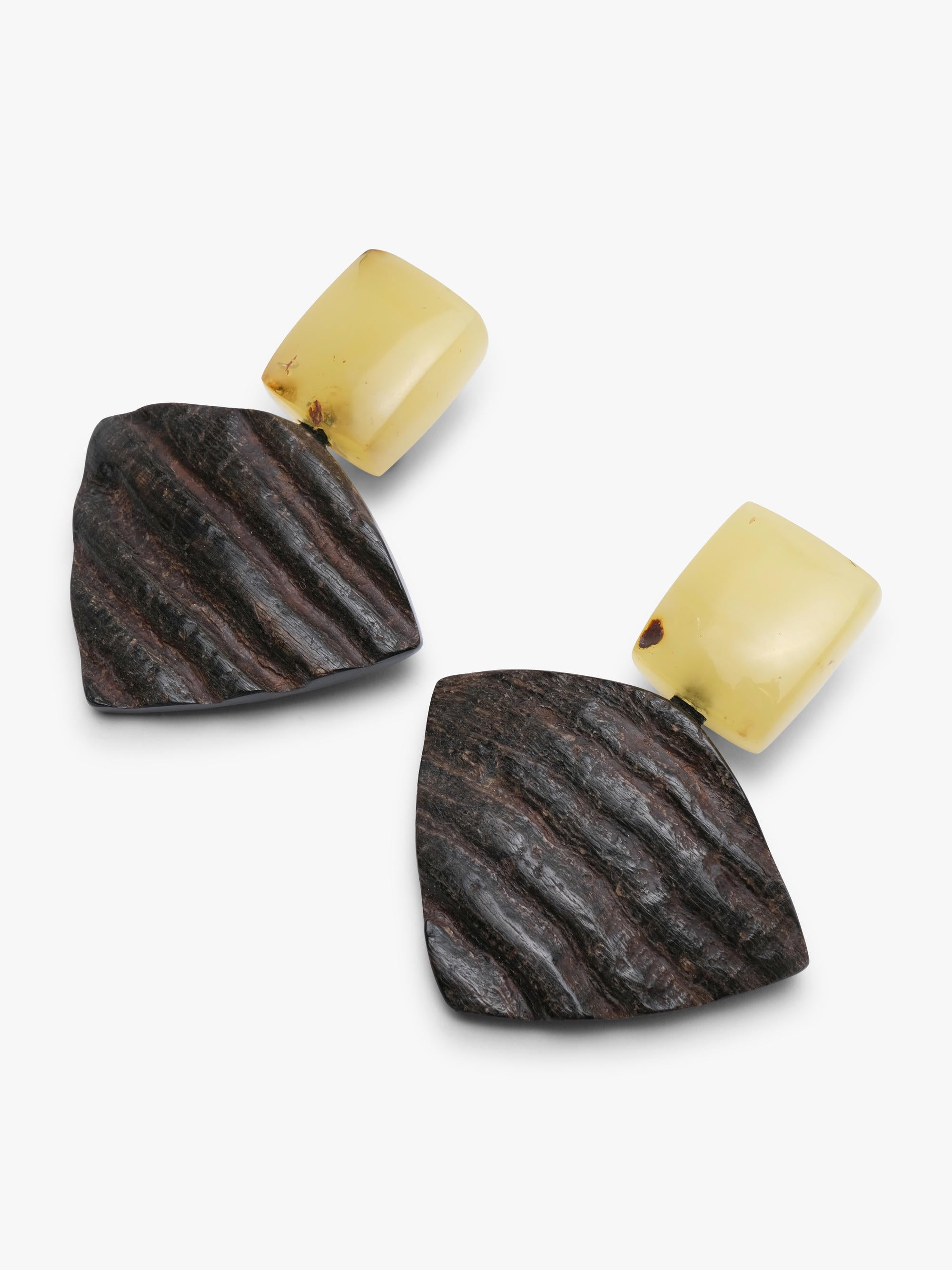 A pair of statement earrings featuring textured dark brown wood-like shapes with horizontal grooves and smooth, rounded pale yellow top studs, displayed on a clean white background.