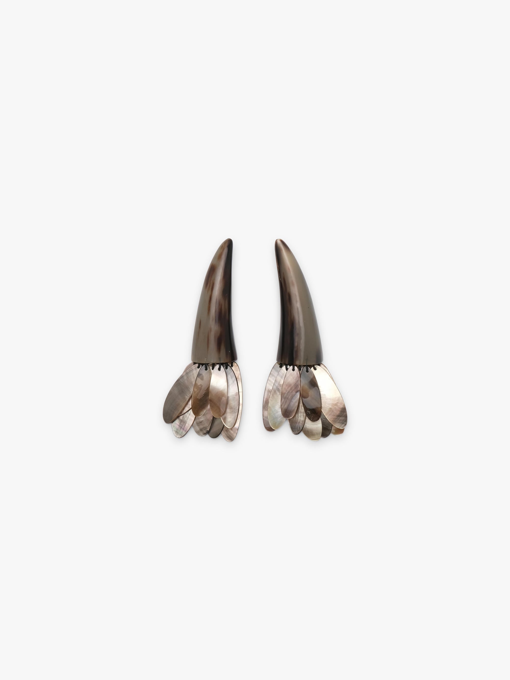 A pair of statement earrings featuring dark brown horn-like spikes with layered silver and iridescent shell petal details at the bottom, set against a plain light gray background.