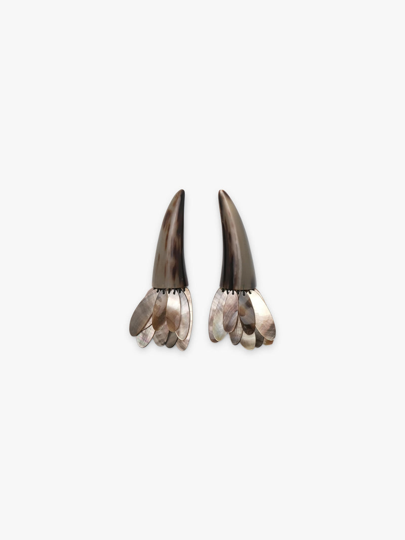 A pair of statement earrings featuring dark brown horn-like spikes with layered silver and iridescent shell petal details at the bottom, set against a plain light gray background.