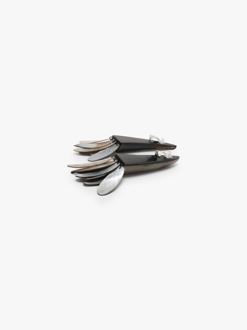 A pair of statement earrings featuring dark brown horn-like spikes with layered silver and iridescent shell petal details at the bottom, set against a plain light gray background.