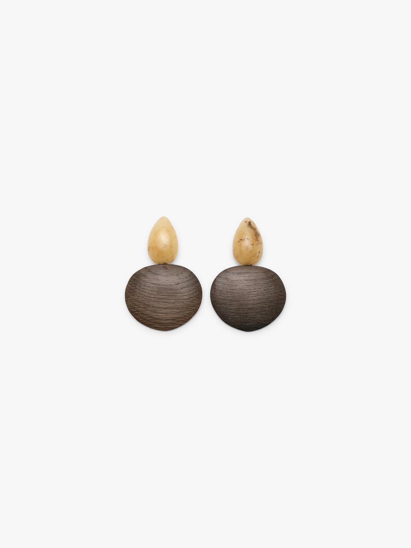 A pair of handmade wooden earrings featuring round dark brown wood discs and teardrop-shaped cream-colored amber tops, displayed on a clean white background.