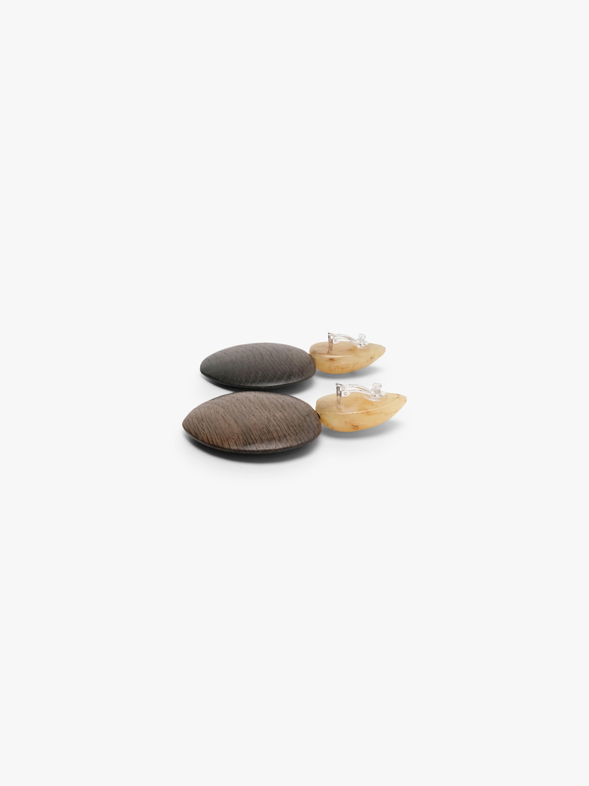 A pair of handmade wooden earrings featuring round dark brown wood discs and teardrop-shaped cream-colored amber tops, displayed on a clean white background.