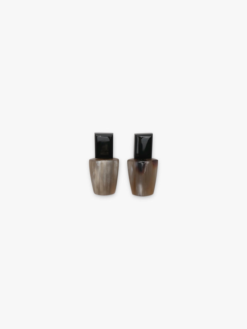 A pair of earrings with a black top and a greyish brown bottom, displayed on a white background