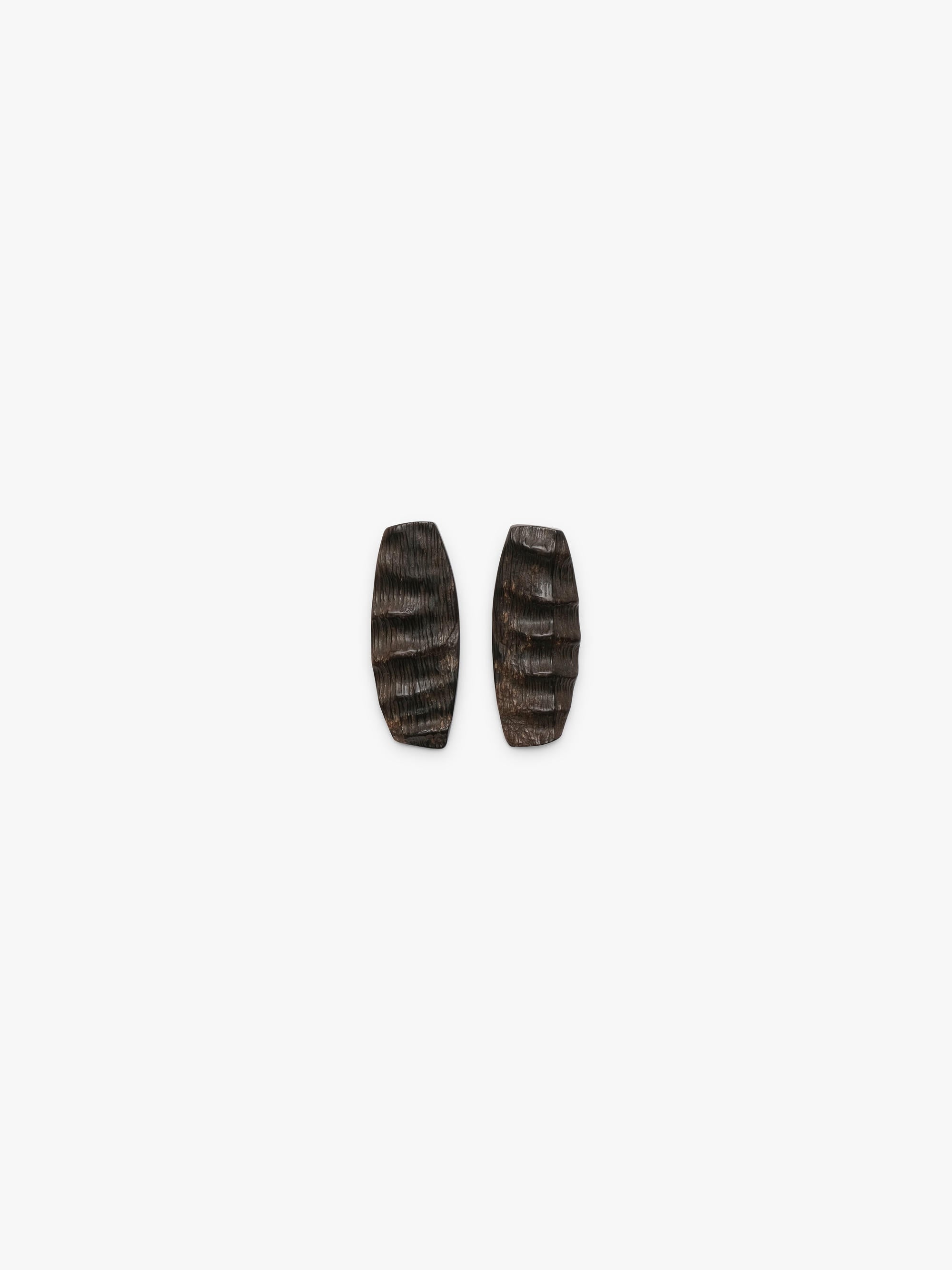 A pair of elongated, textured horn earrings in dark brown, displayed on a white background