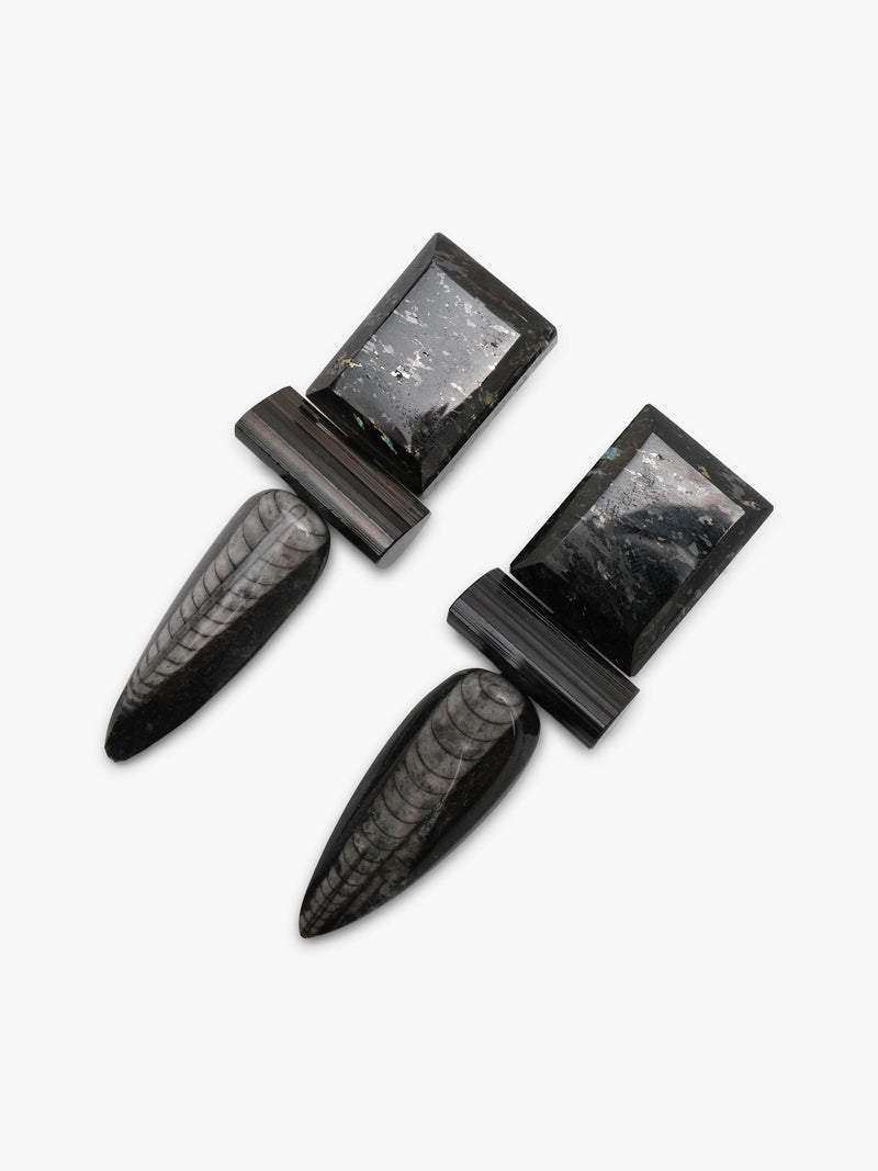 A pair of black and gray stone cuff earrings with elongated teardrop-shaped stone sections and rectangular stone end caps, displayed on a clean white background.