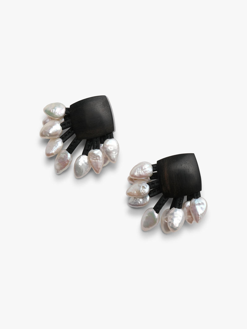 A pair of black fan-shaped stud earrings with dangling silver-toned and white freshwaterpearls, shown on a plain light gray background.
