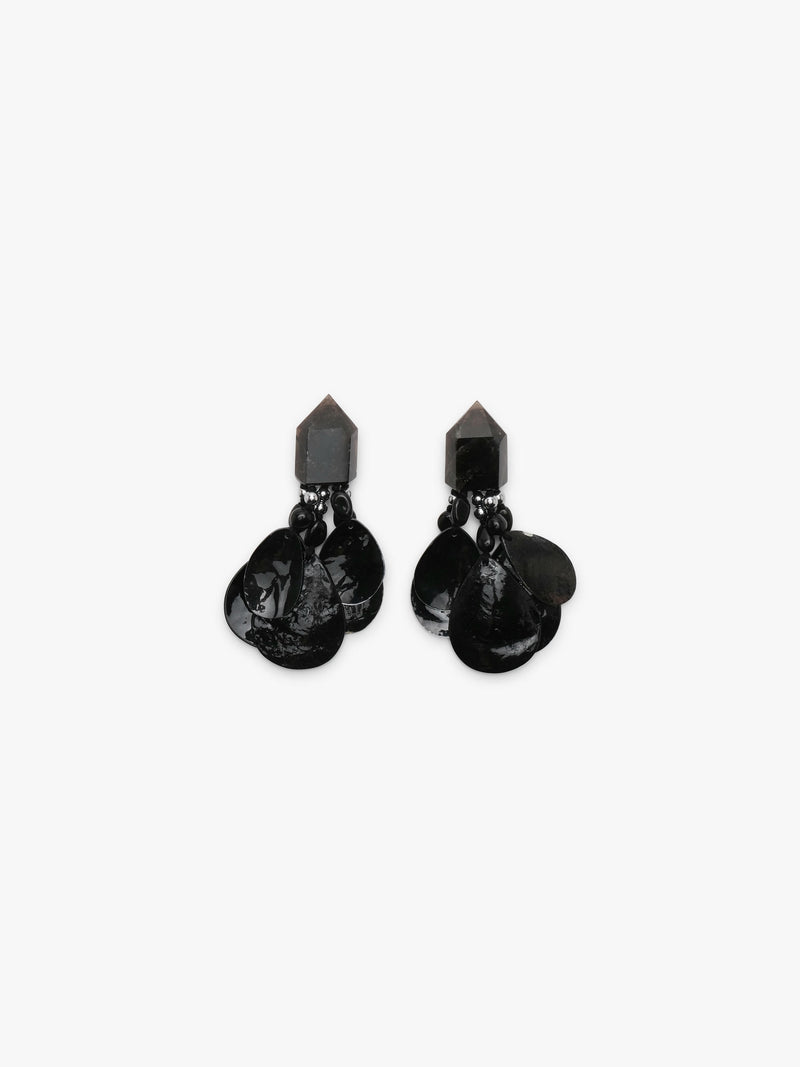A pair of black dangle earrings with a geometrical top and black shell tassles, displayed on a white background