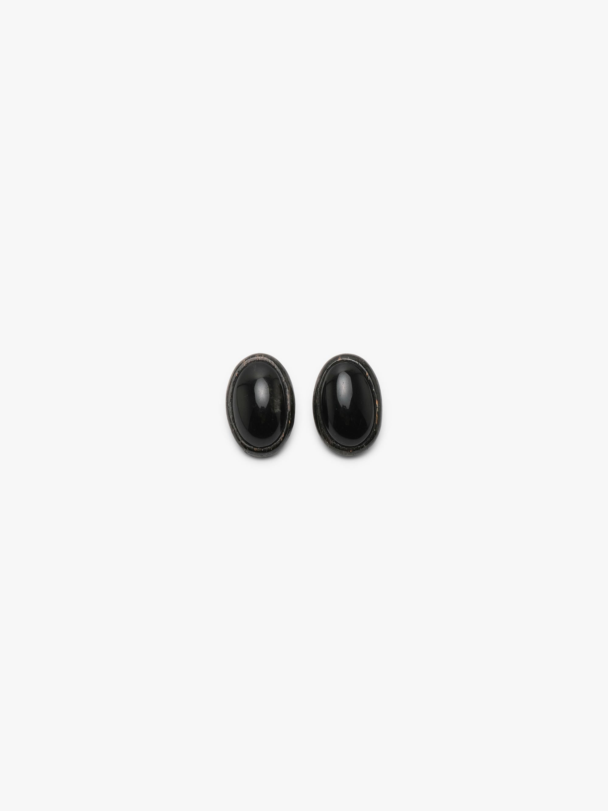 A pair of oval black cabochon stud earrings with a dark textured metallic stone, shown on a clean white background.