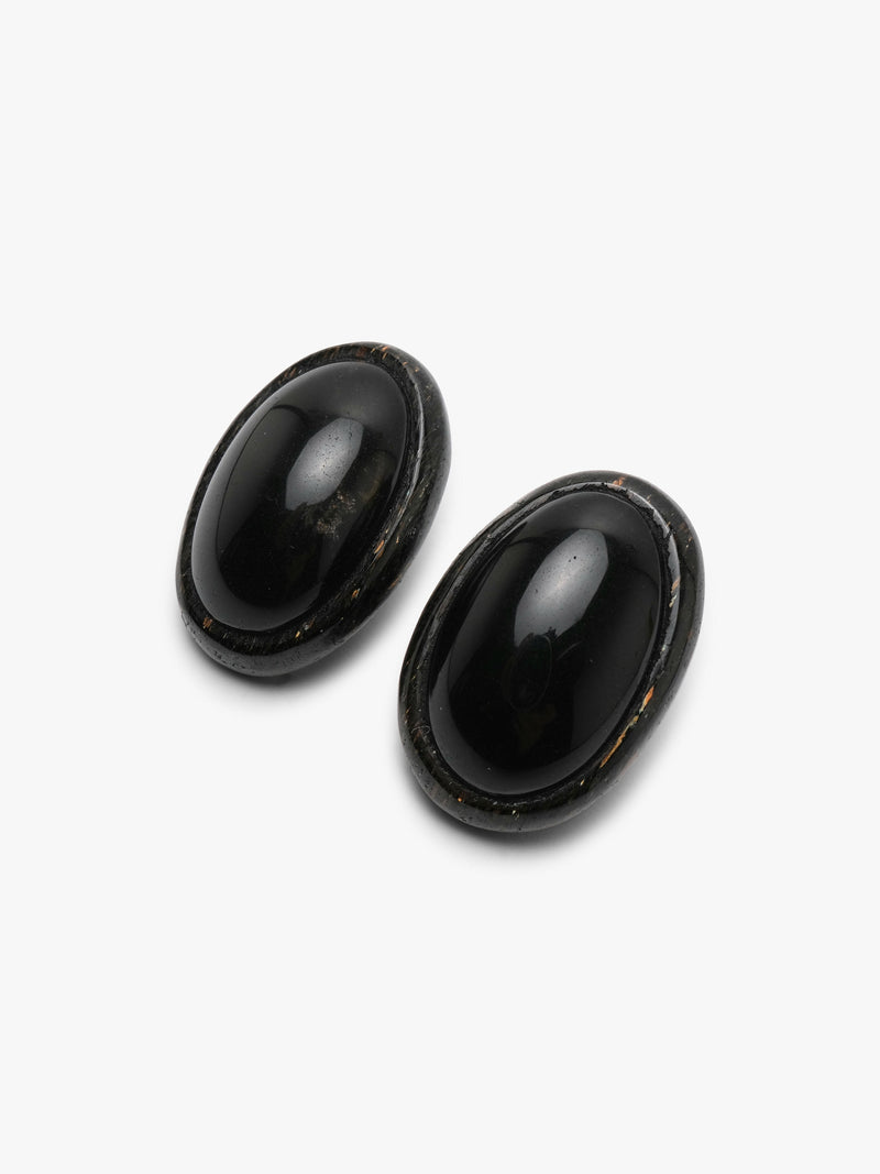 A pair of oval black cabochon stud earrings with a dark textured metallic stone, shown on a clean white background.