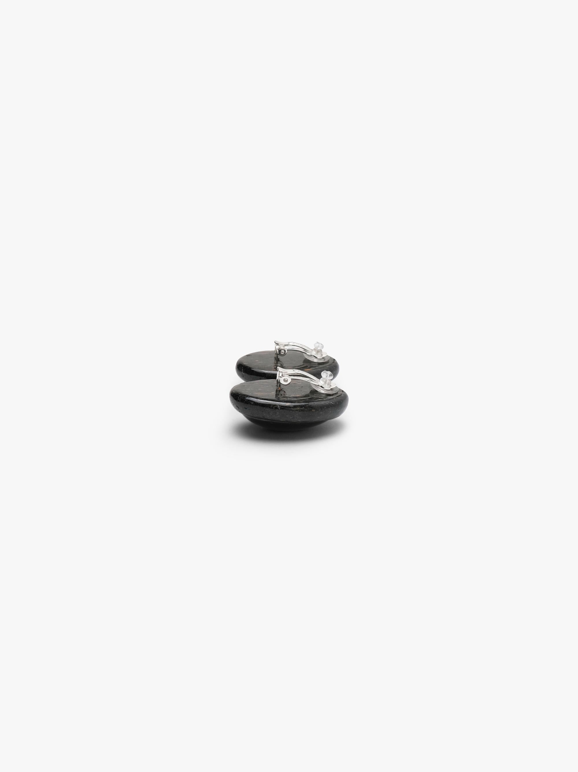 A pair of oval black cabochon stud earrings with a dark textured metallic stone, shown on a clean white background.