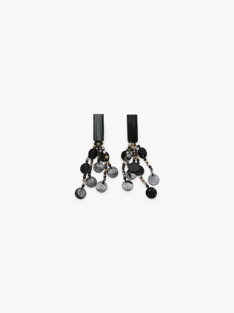 A pair of statement drop earrings featuring black and gray marbled disc charms, small brown and white beads, and black rectangular posts, shown on a light gray background.