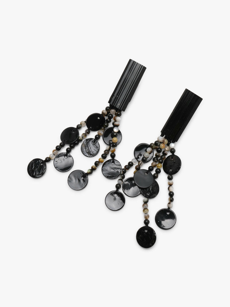 A pair of statement drop earrings featuring black and gray marbled disc charms, small brown and white beads, and black rectangular posts, shown on a light gray background.