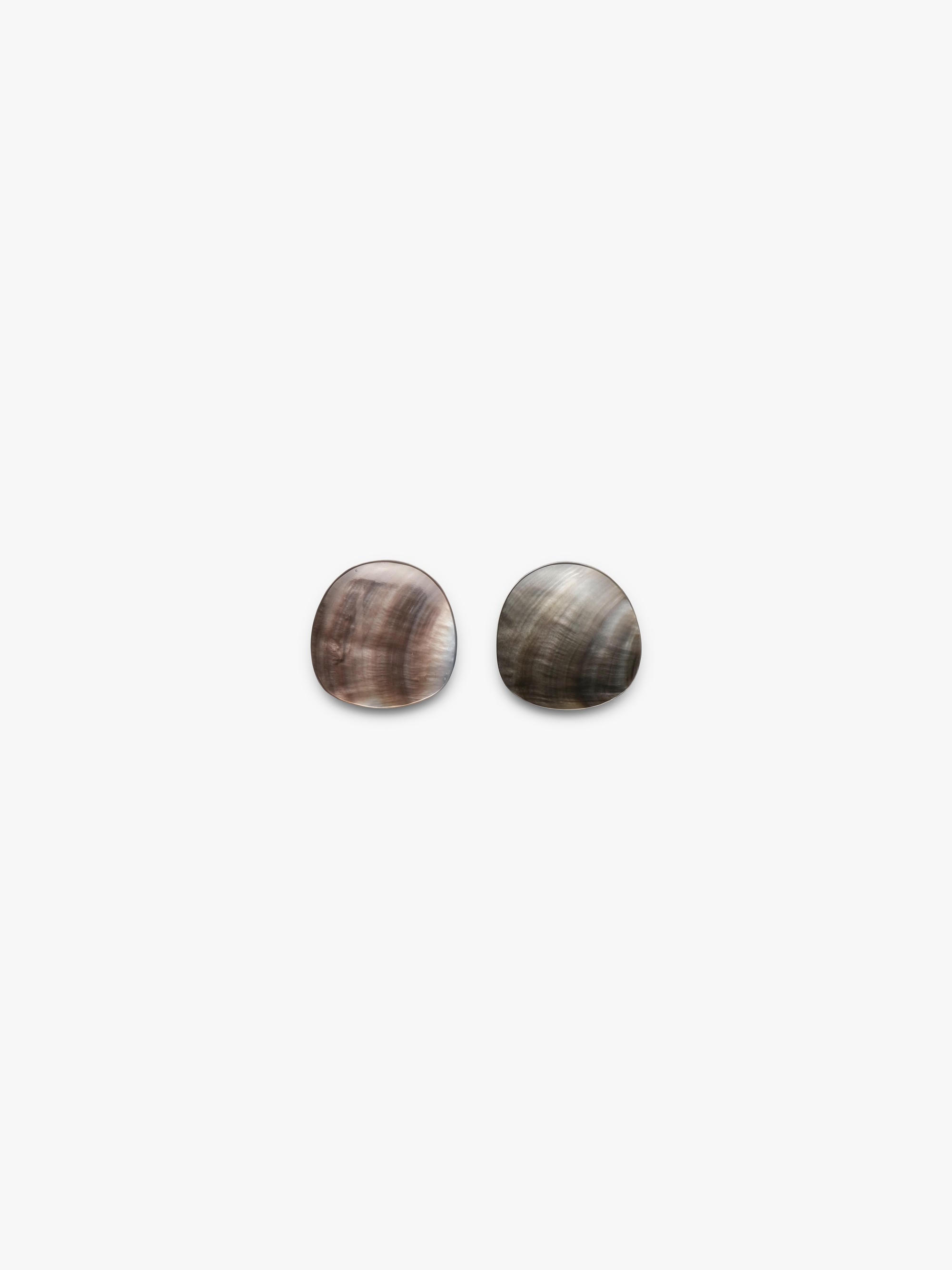 A pair of oval stud earrings with a natural mother-of-pearl shell finish, featuring iridescent brown, gray, and white swirls, set against a plain light gray background.