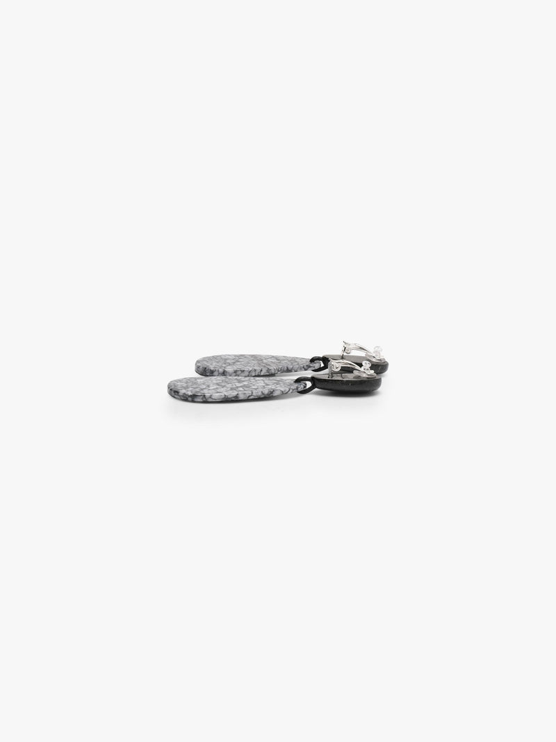 Earrings with black tops and an oval shaped stone in a textured black and grey pattern underneath, shown on a white background