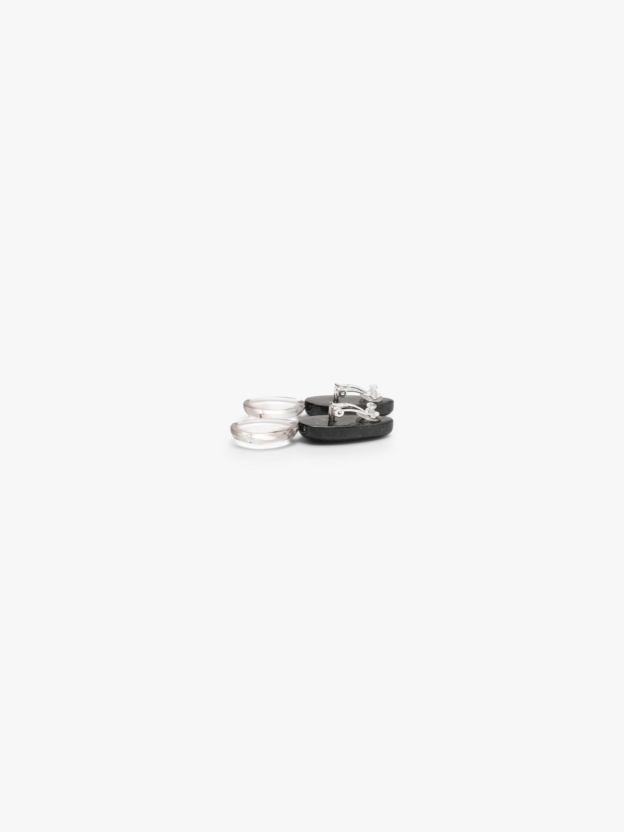The backside of A pair of drop earrings featuring polished black obsidian teardrop pendants suspended from smooth, milky white rose quartz oval drops, shown on a clean white background.