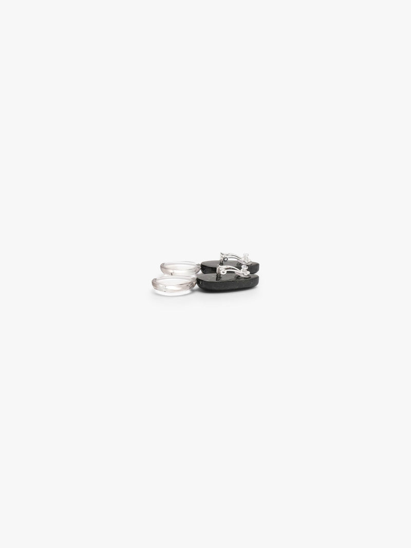 The backside of A pair of drop earrings featuring polished black obsidian teardrop pendants suspended from smooth, milky white rose quartz oval drops, shown on a clean white background.