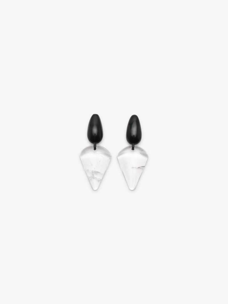 A pair of geometric drop earrings featuring a matte black teardrop-shaped top and a clear, faceted triangular drop with a subtle white marble texture below, set against a solid off-white background.