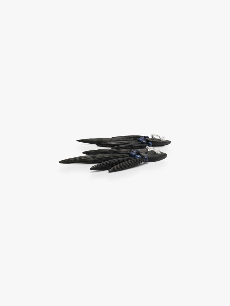 The backside of A pair of statement dangle earrings made from dark wood slices and small dark blue beads, displayed on a clean white background.