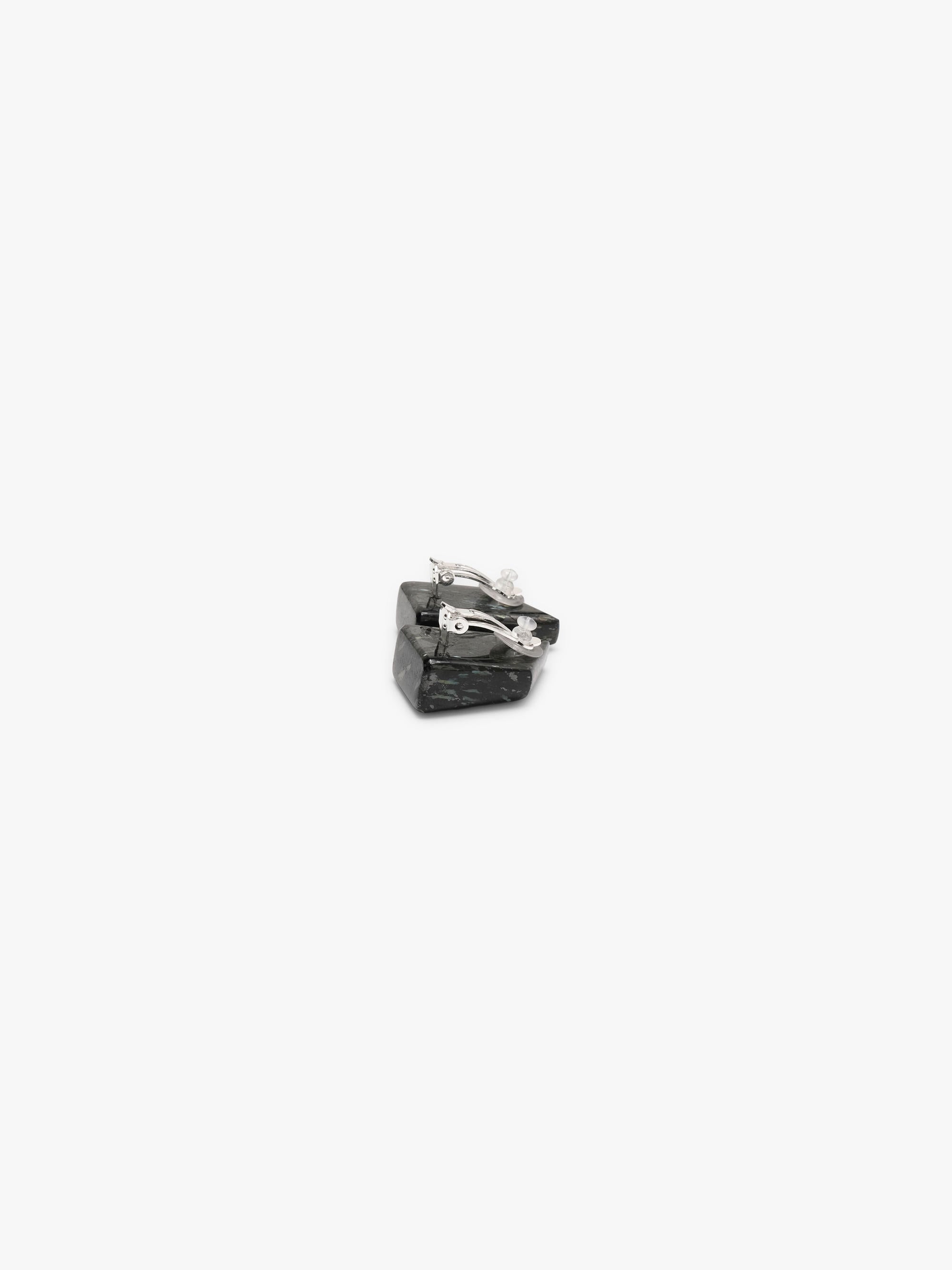 Black button earrings with small inclusions, shown on a white background
