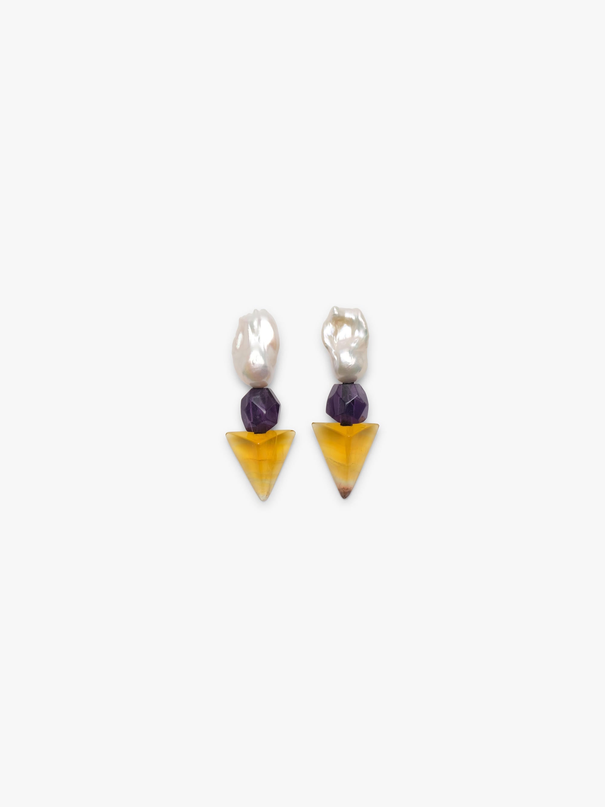 Baroque pearl earrings with a faceted purple and yellow stones underneath. Displayed on a white background