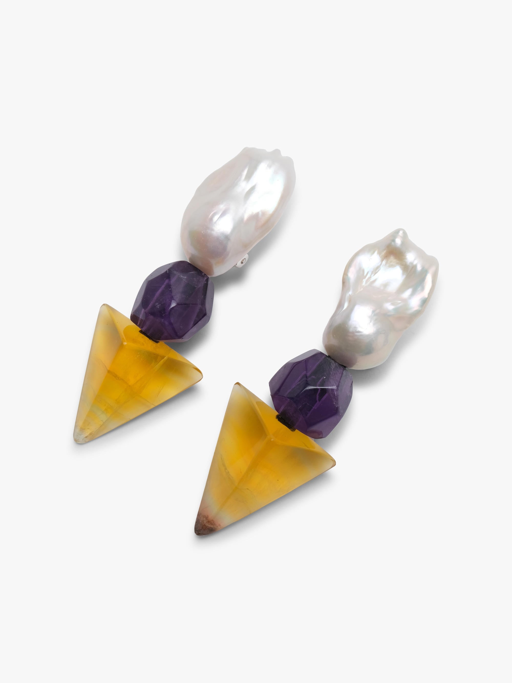 Baroque pearl earrings with a faceted purple and yellow stones underneath. Displayed on a white background