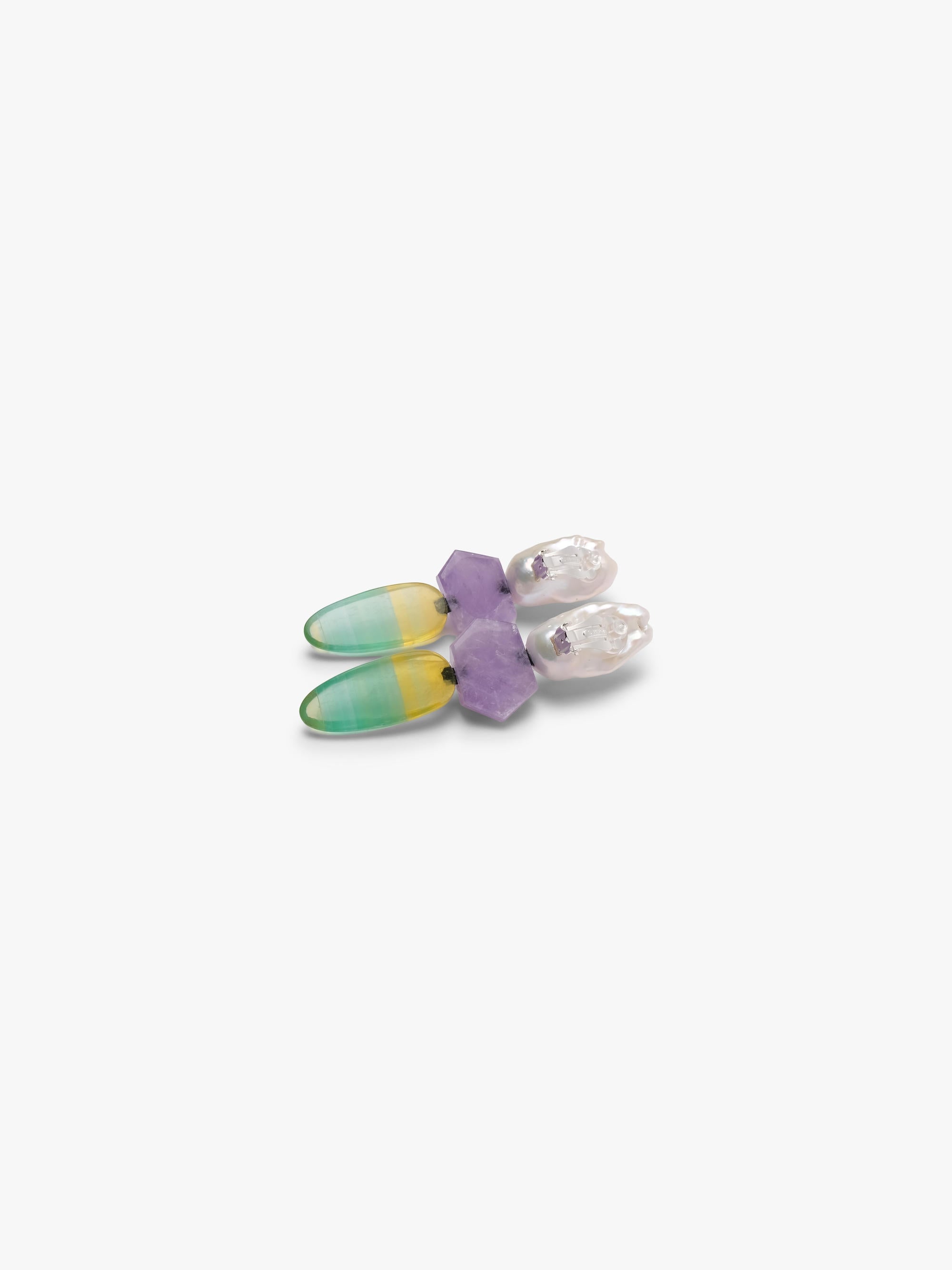 Baroque pearl dangle earrings with purple and yellowish green stones underneath. Displayed on a white background