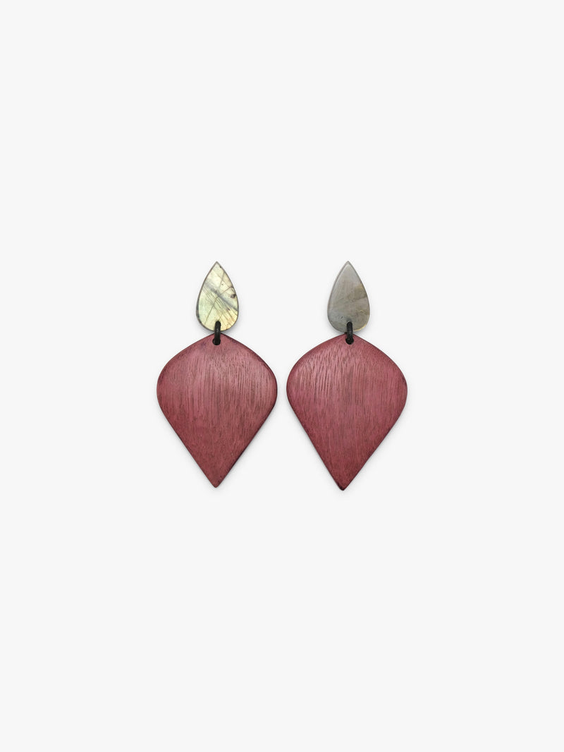A pair of geometric drop earrings featuring textured, brushed rose-pink teardrop-shaped pendants with small, pointed silver-toned studs on a light gray background.
