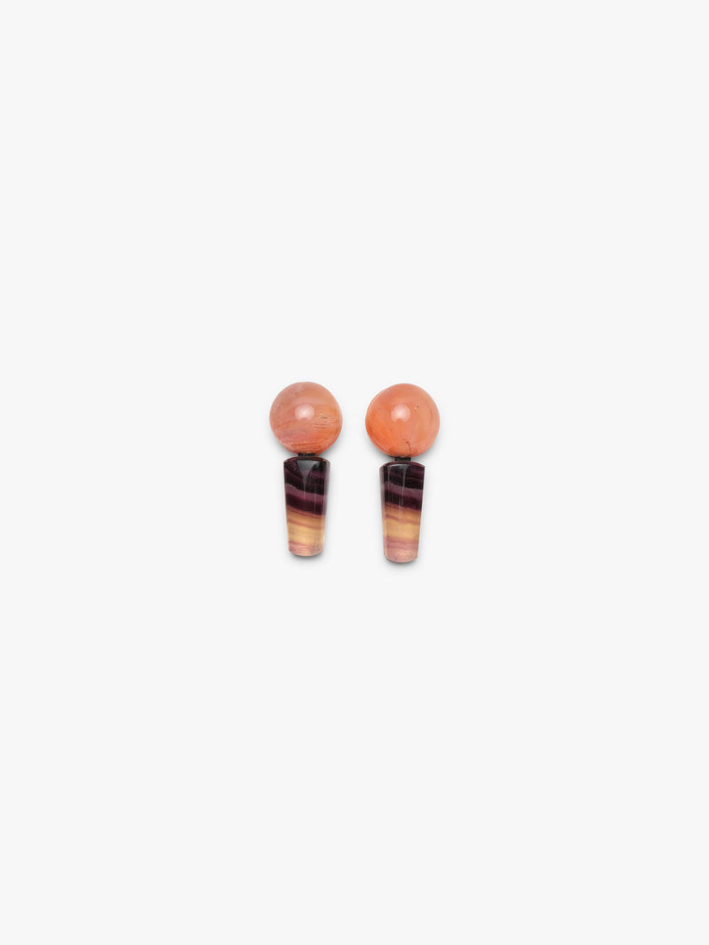 A pair of drop earrings featuring round peach-orange beads on top of tapered marbled dark brown, black, and orange stone sections, shown against a plain light gray background.