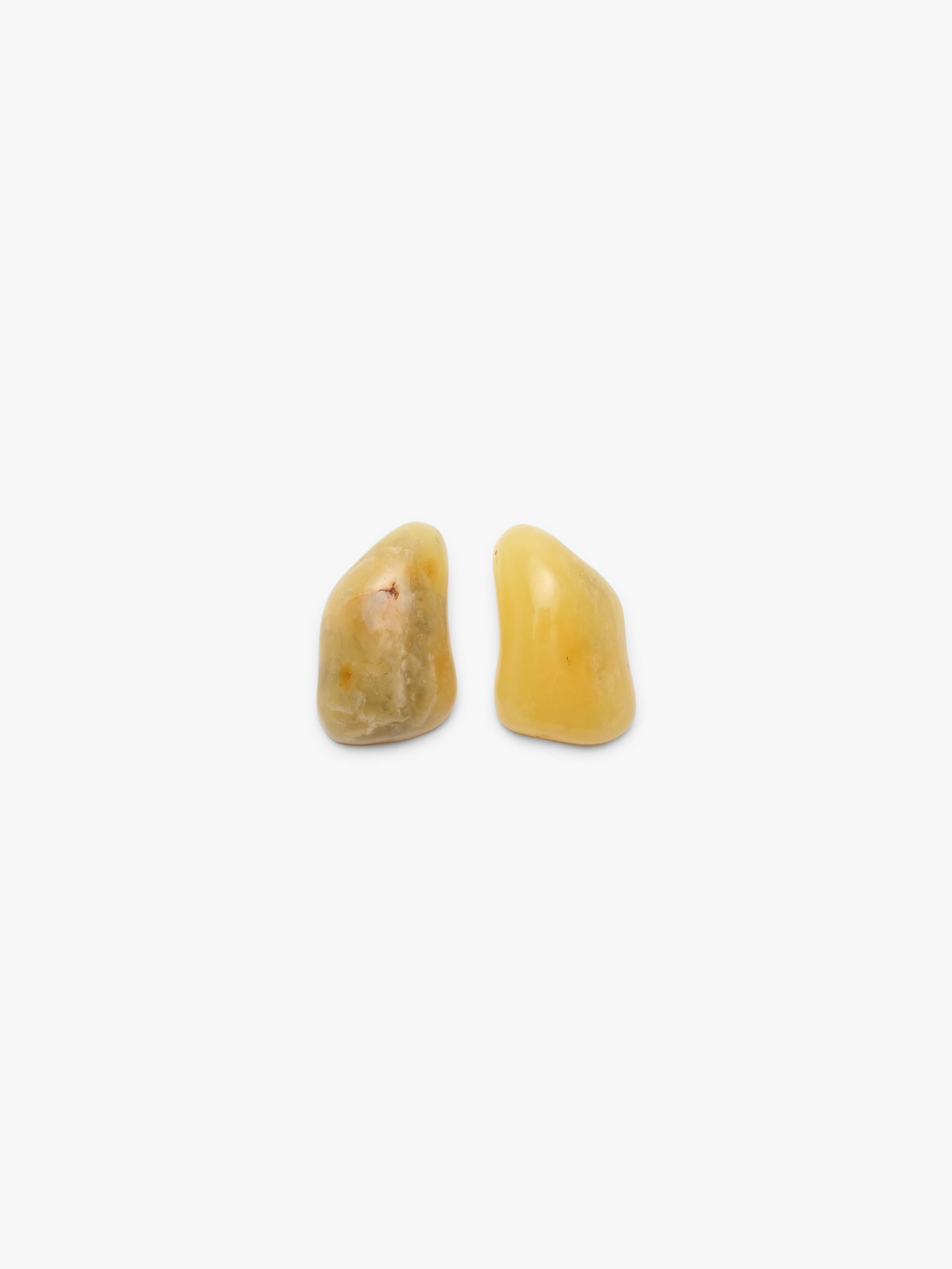 A pair of irregular yellow amber earrings displayed on a white background