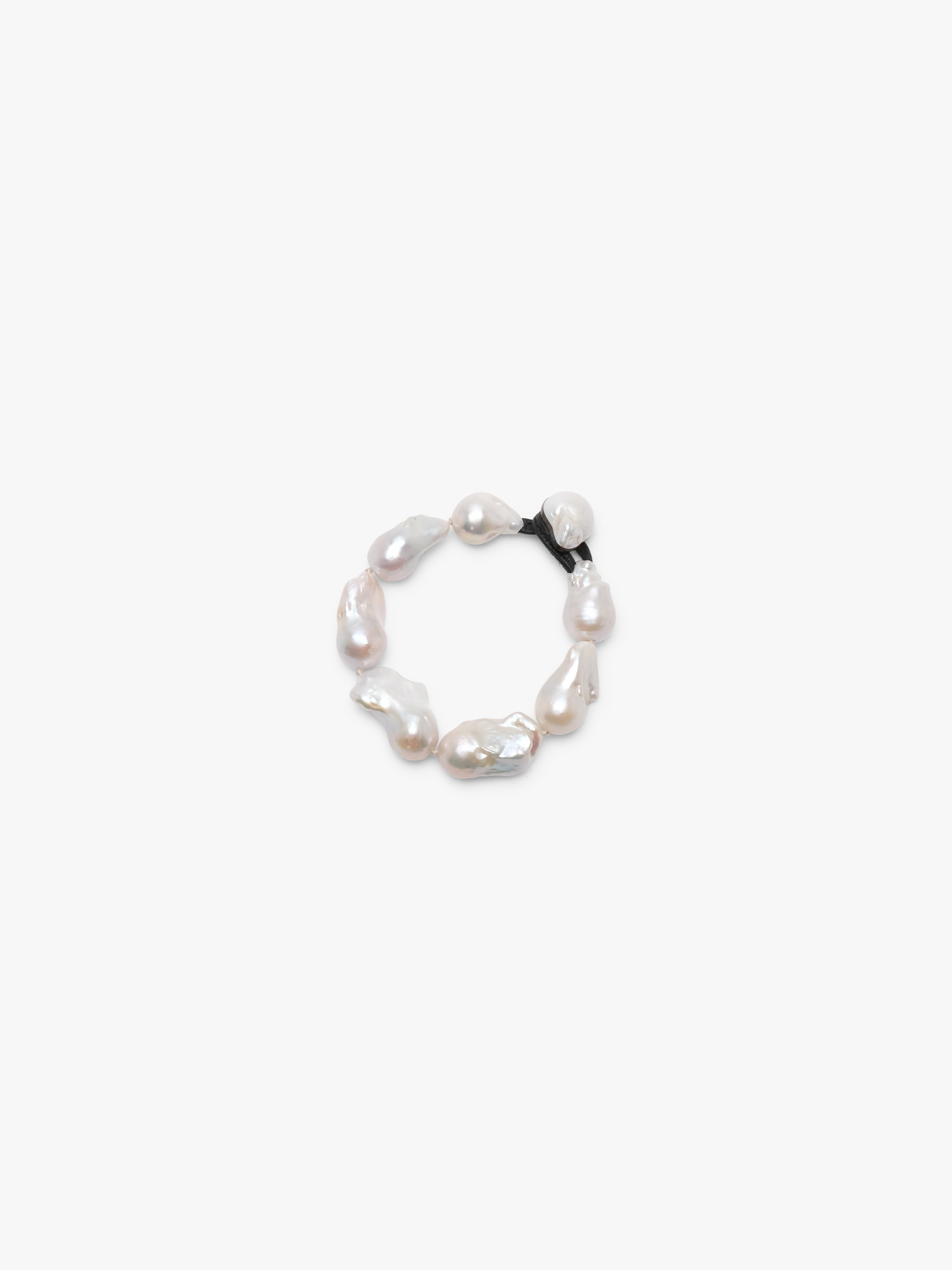 A bracelet made of baroque pearls with a leather strap, featuring a toggle clasp lock.