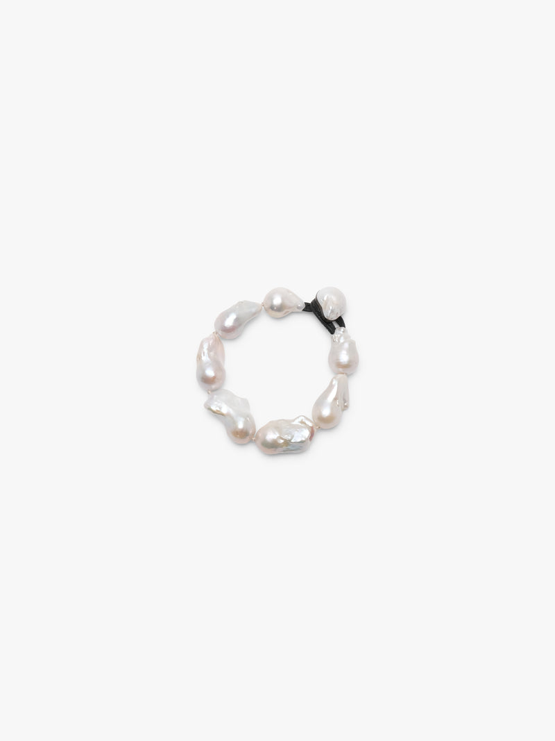 A bracelet made of baroque pearls with a leather strap, featuring a toggle clasp lock.