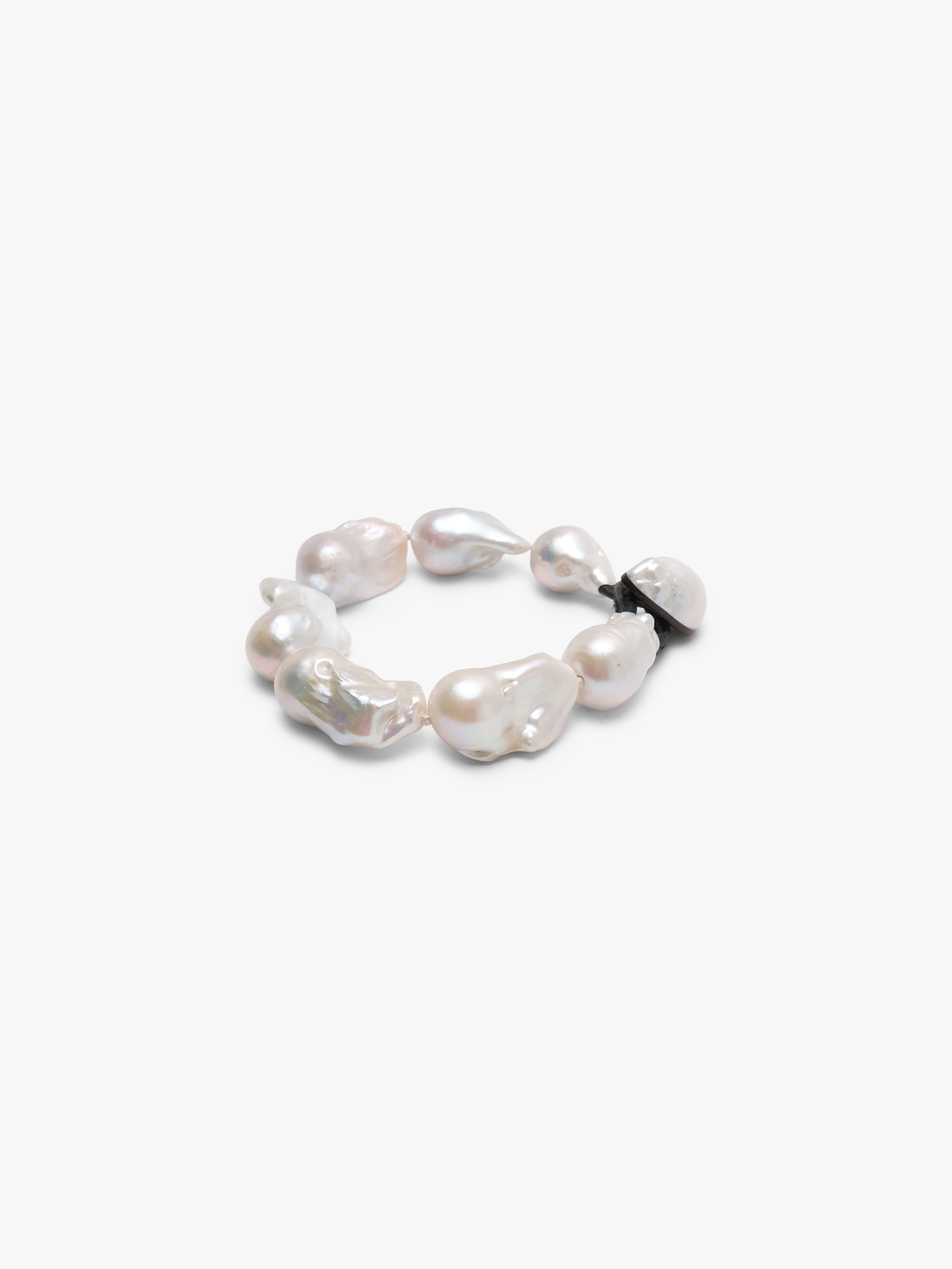A bracelet made of baroque pearls with a leather strap, featuring a toggle clasp lock.