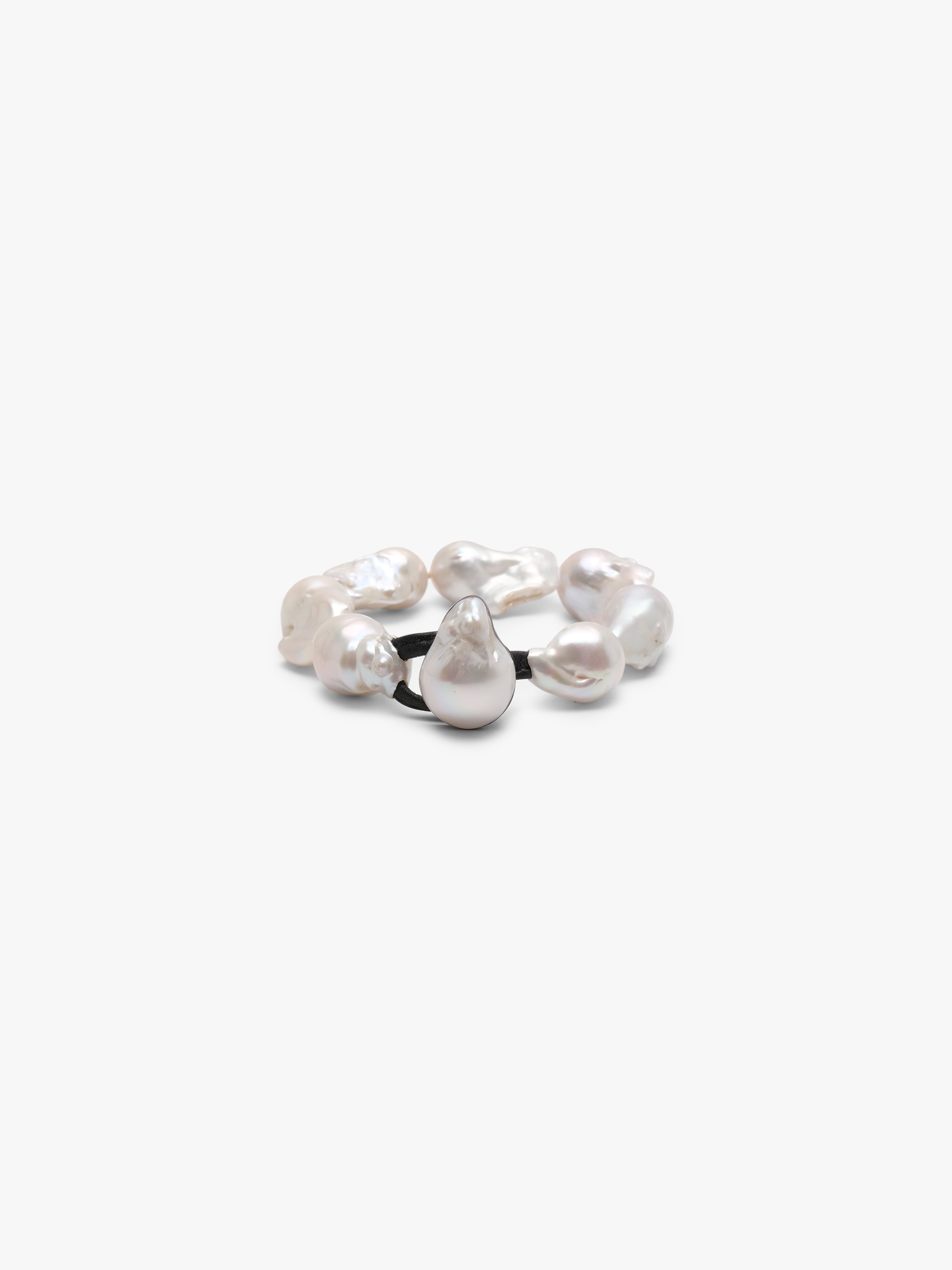 A bracelet made of baroque pearls with a leather strap, featuring a toggle clasp lock.