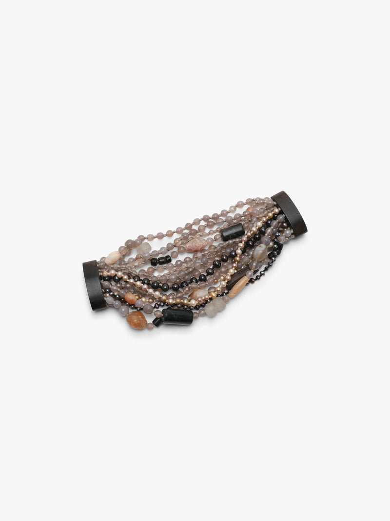 Multistrand bracelet in grey, beige and orange colours. Placed on a white background.
