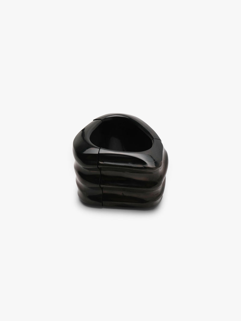Black bracelet made of buffalo horn, with natural ridges, displayed on a white background