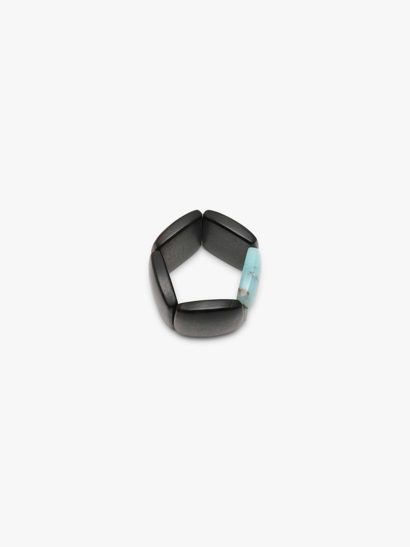 A bracelet made from black and light blue stone squares, displayed on a white background